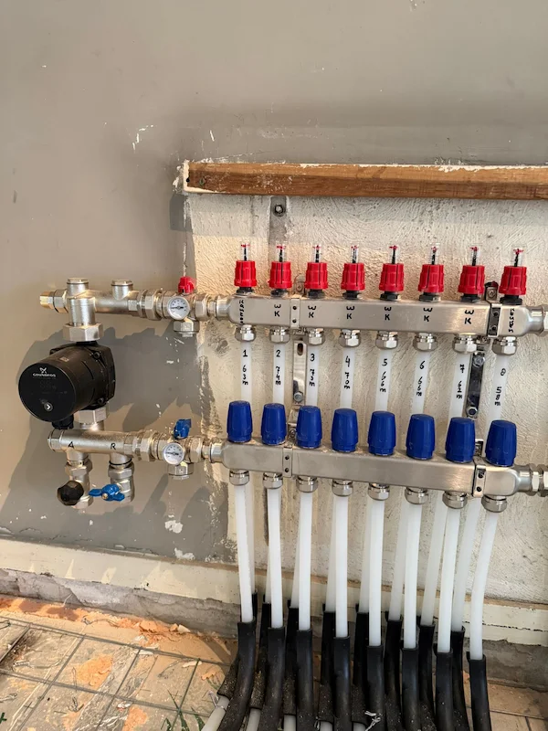 Vloerverwarming aangelegd en cementdekvloer gestort in Tilburg 9 Vloerverwarming verdeler met meerdere groepen en aangesloten leidingen tijdens installatie